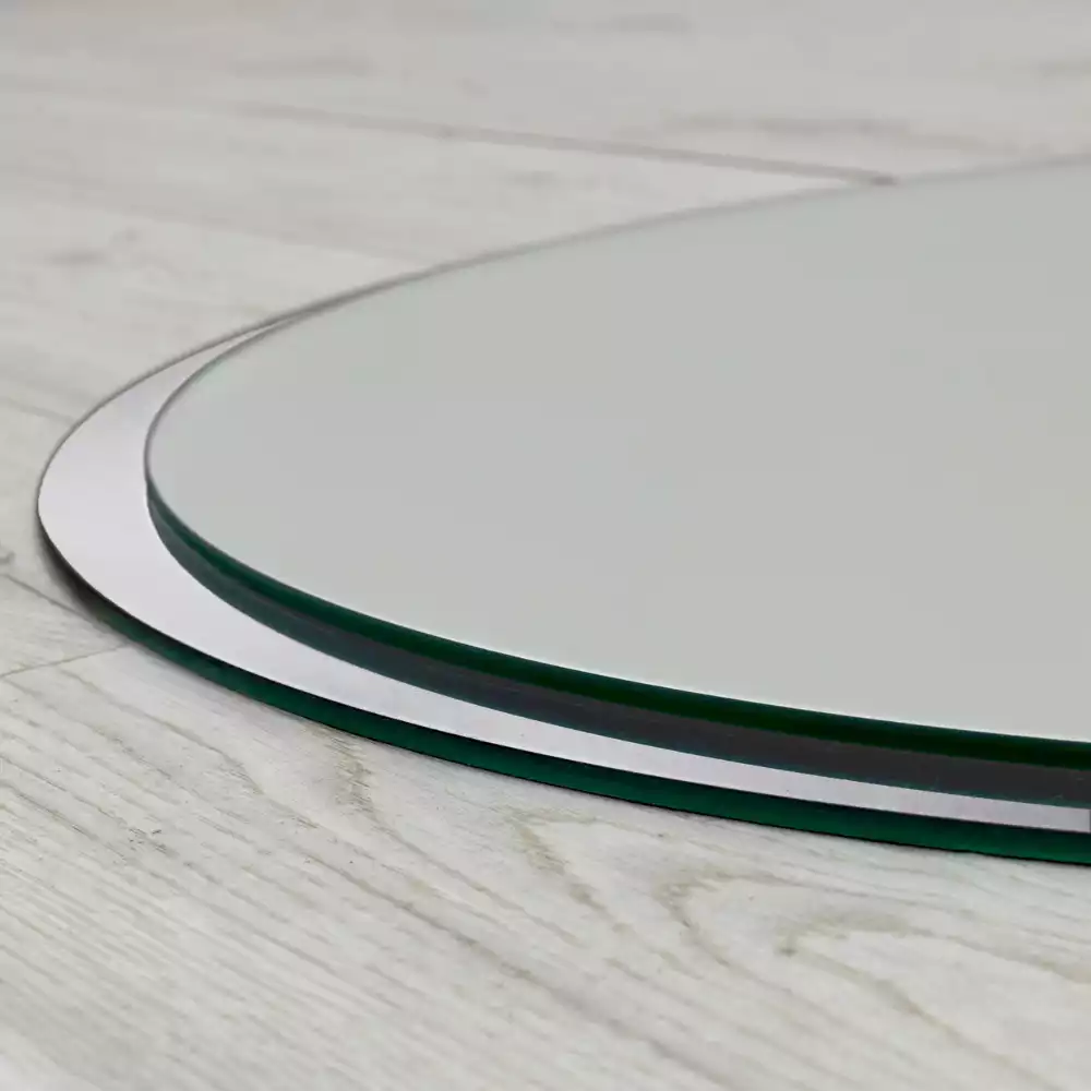 Miroir oval suspendu dans un cadre blanc